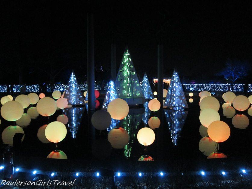 Center pond with balls & trees decoarated with lights at Garden Glow at Missouri Botanical Gardens