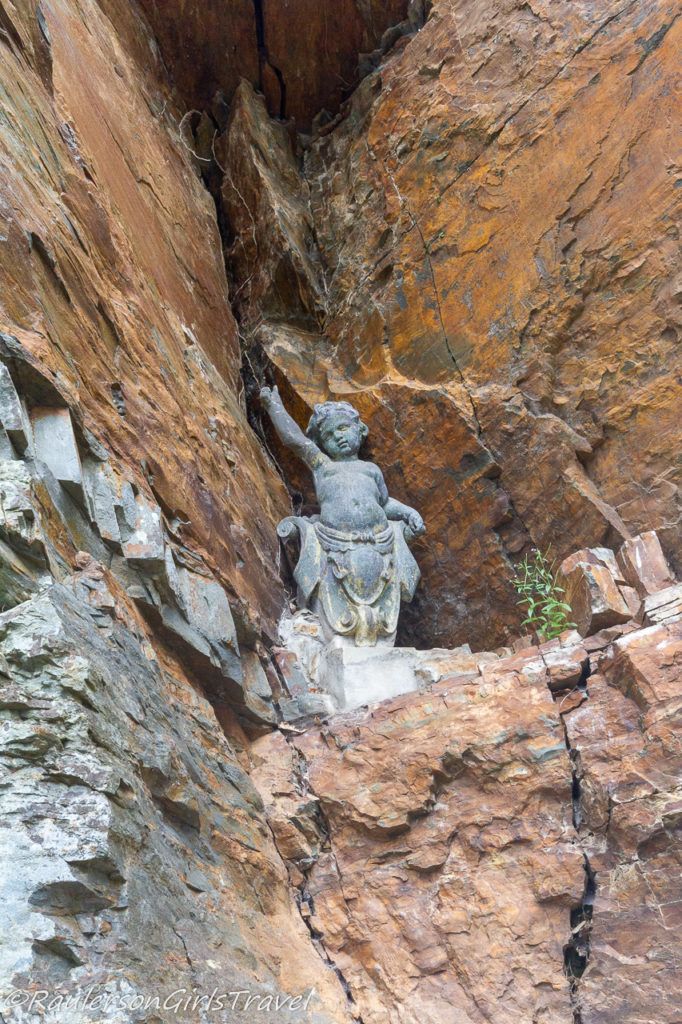 Cherub statue in the rocks in Portmeirion