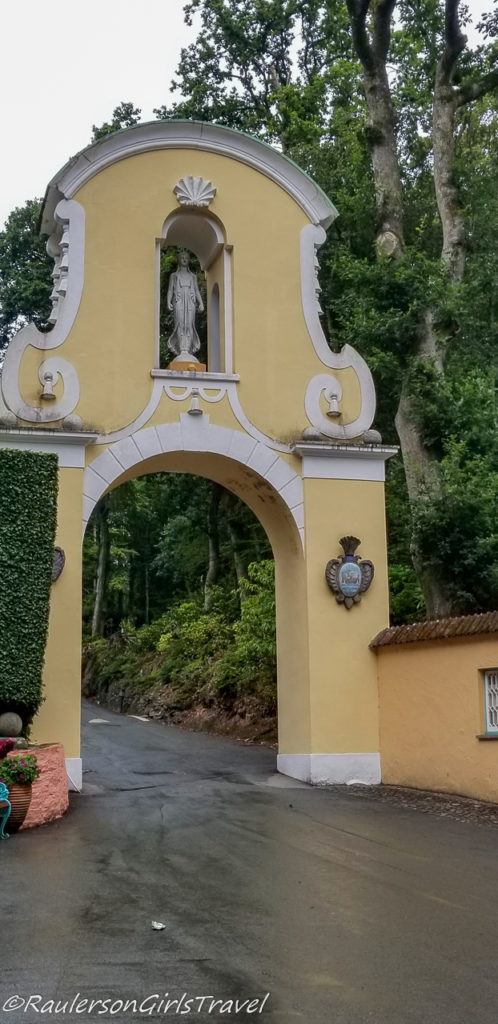 Gate with Greek statue into the Portmeirion Woodlands
