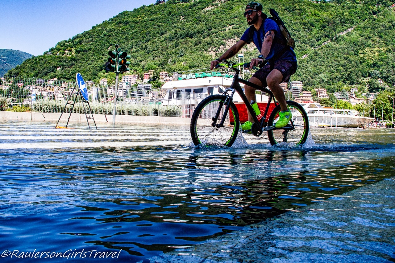 Biker riding through the flooded street of Como