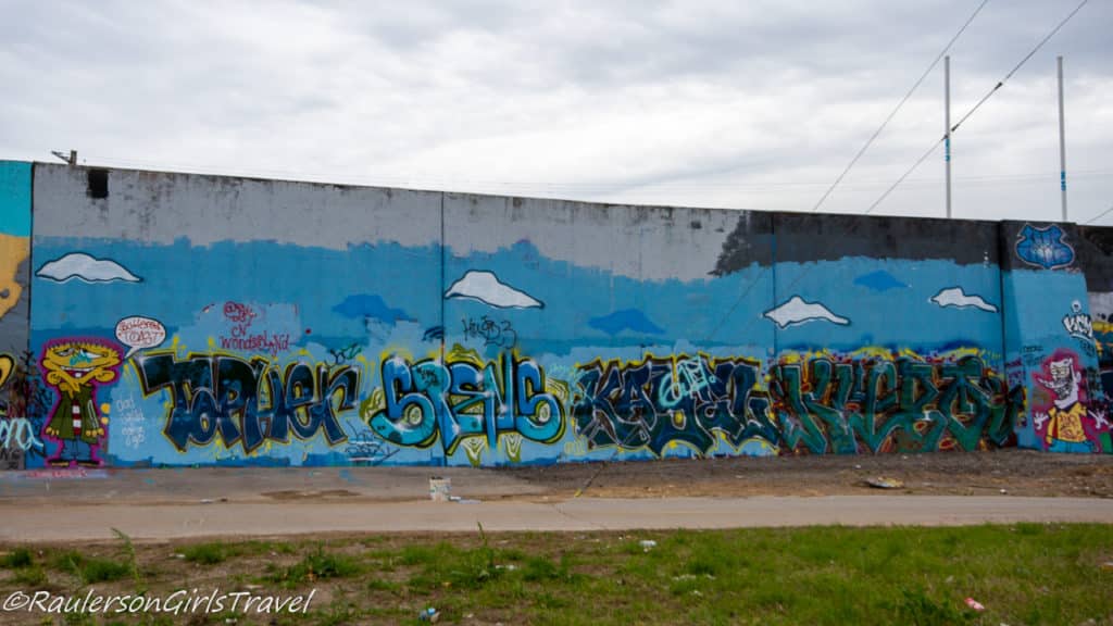 Blue street art with clouds and kid monsters