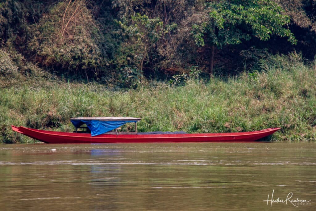 Red long boat on the Mekong River