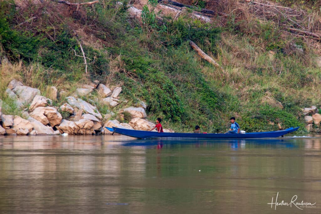 Boys on a Blue Long Boat on the Mekong River