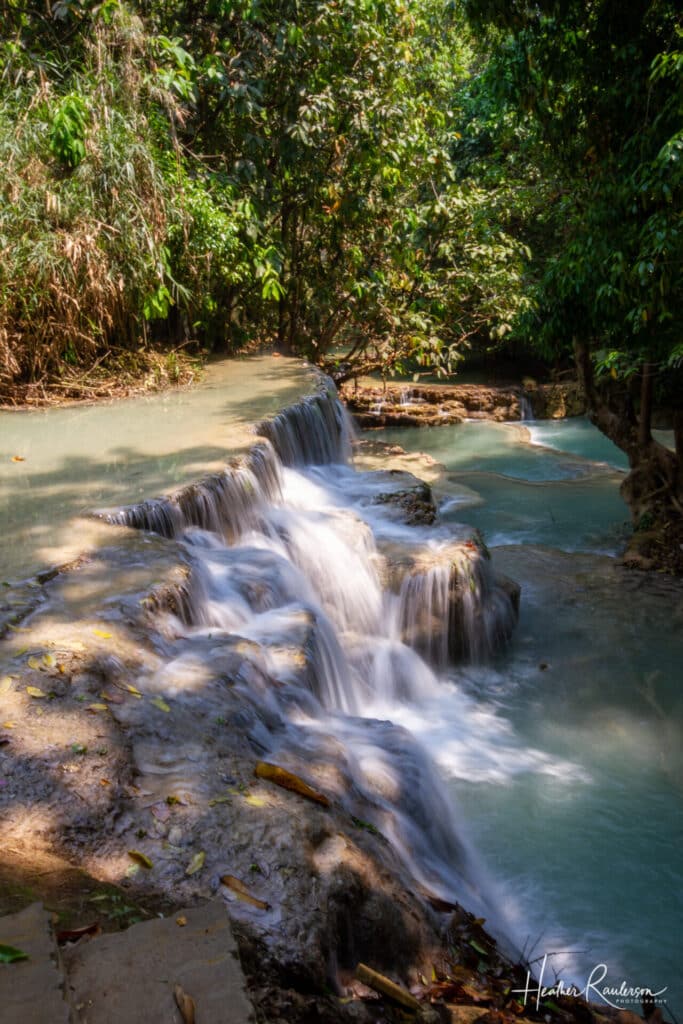 Side view of a waterfall captured with slow shutter speed at Kuang Si Falls