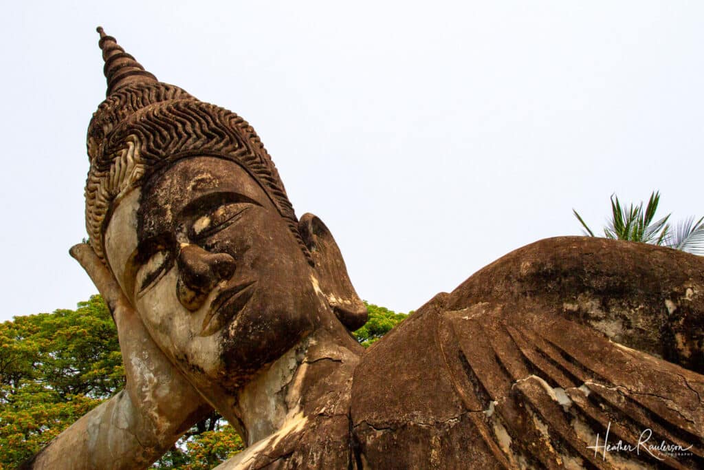 The head of a large reclining statue in Buddha Park