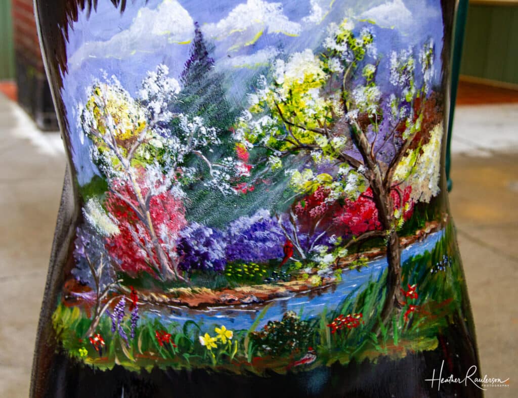 Colorful Spring scene painted on a bear in Hendersonville